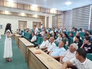 Project team member Bunafsha Rafiyeva delivering a talk to a group in a classroom setting. 